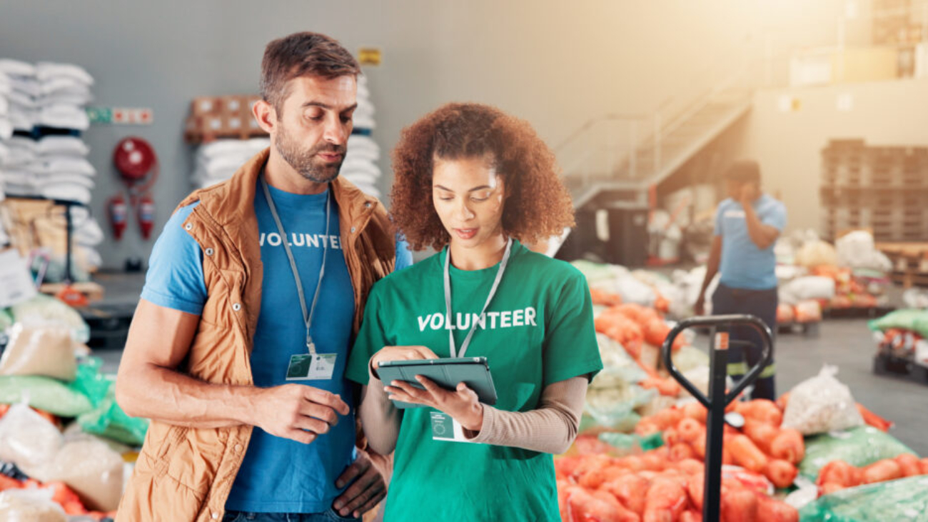 Warehouse, charity and people with tablet, help and review of donations on website and discussion. .