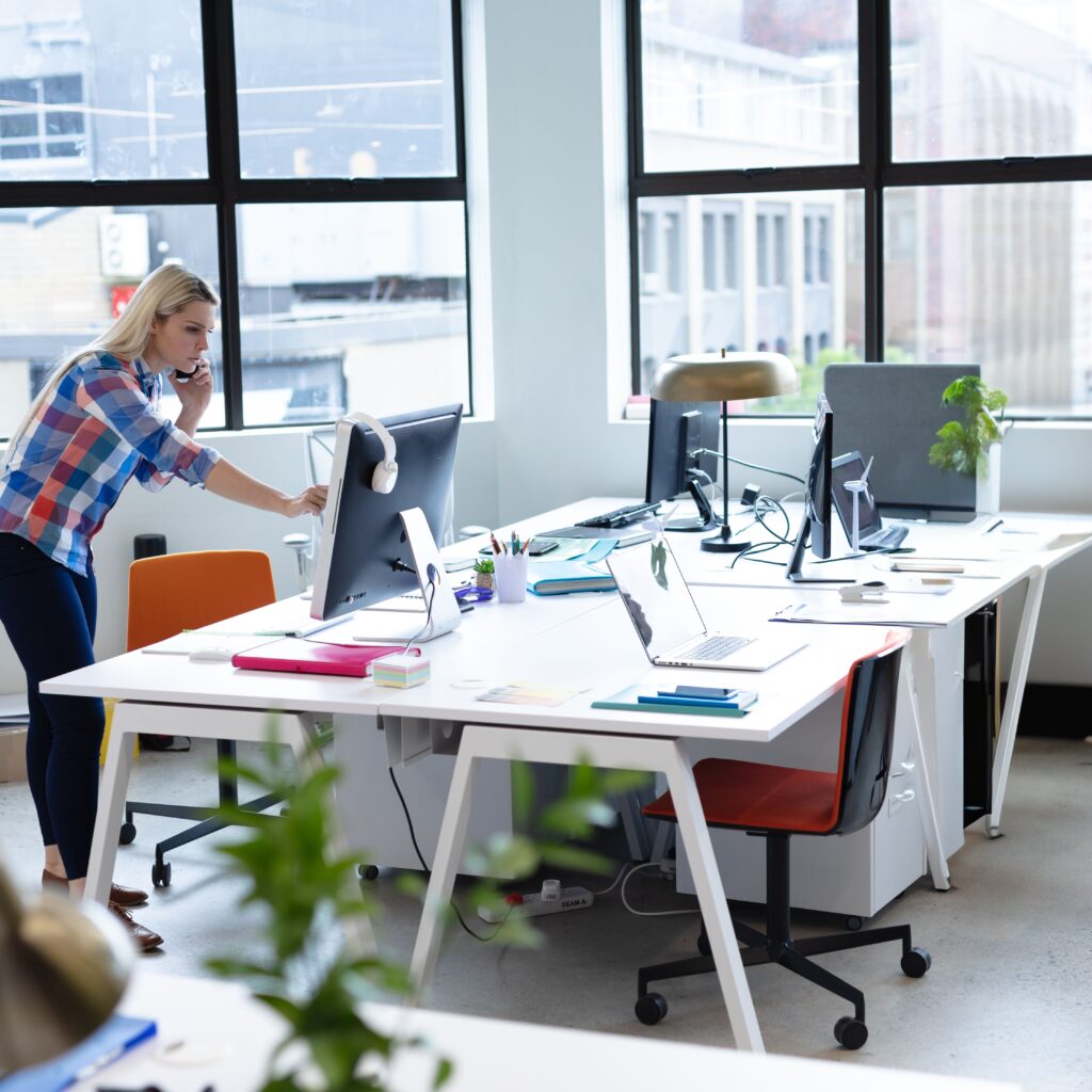 Woman working on finances in an open-plan UK charity office