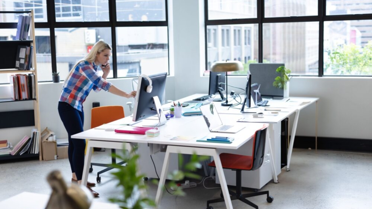 Woman working on finances in an open-plan UK charity office