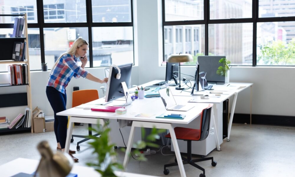 Woman working on finances in an open-plan UK charity office