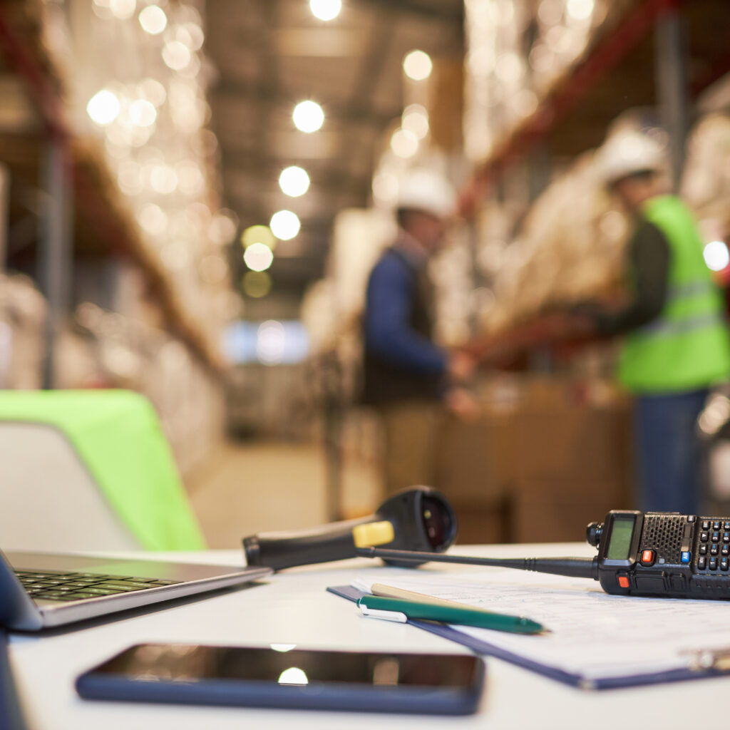 Sage warehouse workspace desk with inventory management tools and documents