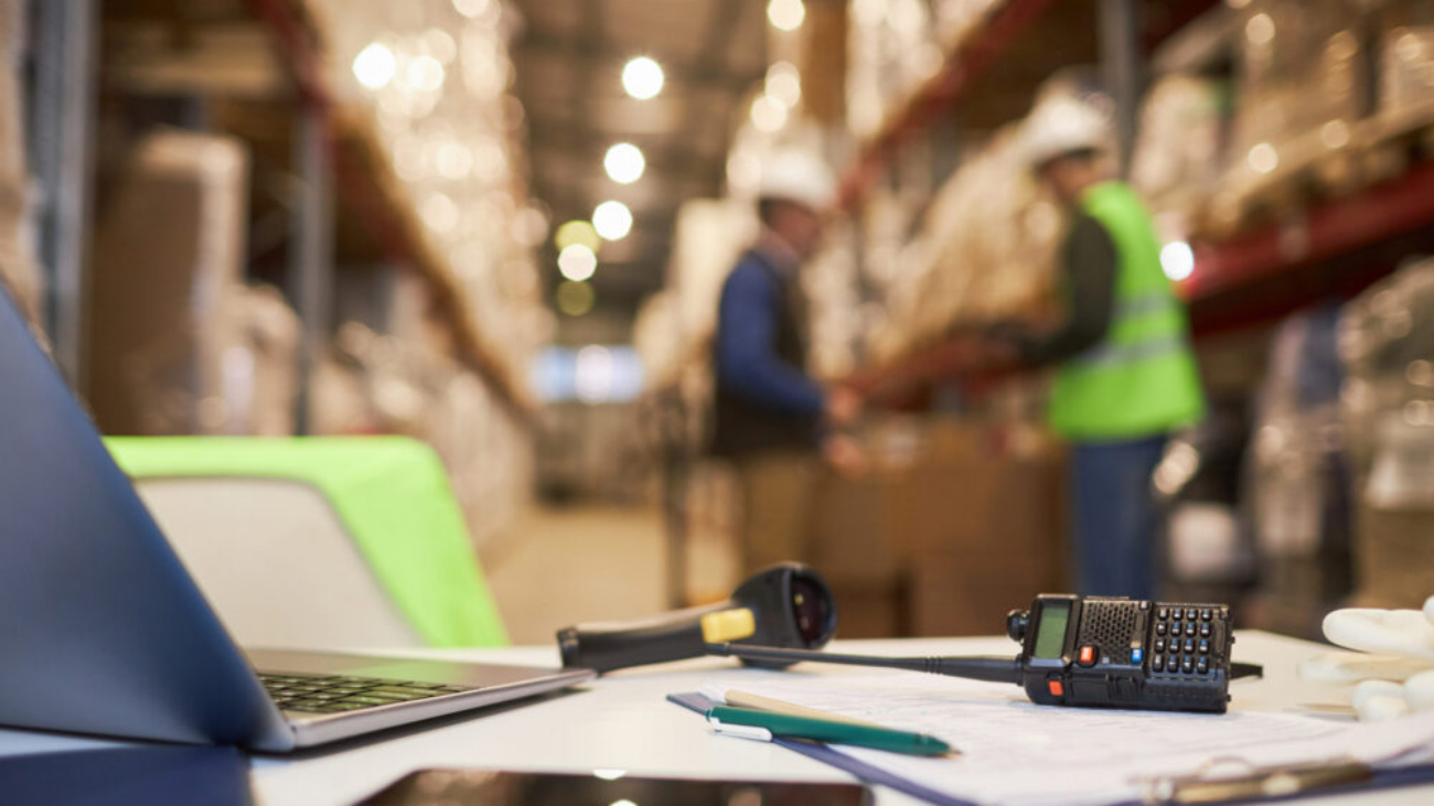 Sage warehouse workspace desk with inventory management tools and documents