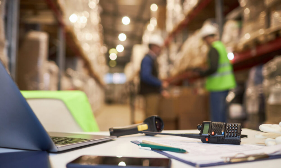 Sage warehouse workspace desk with inventory management tools and documents