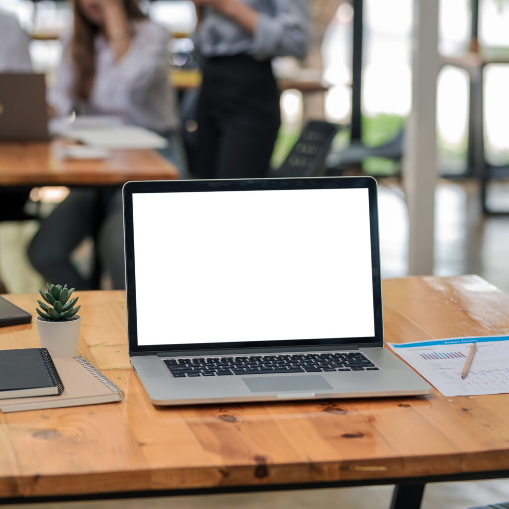 Laptop with blank screen on wooden desk representing Sage Intacct and Sage 200 ERP comparison for UK businesses
