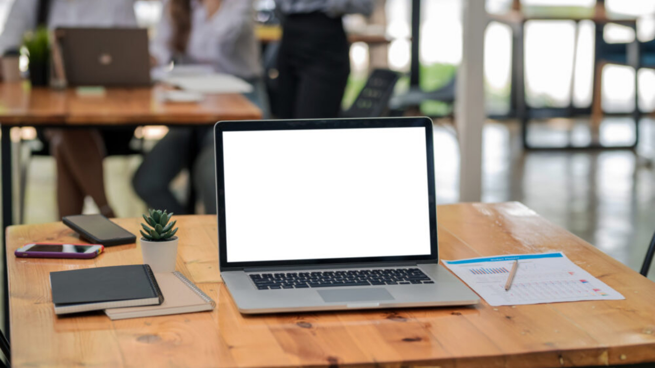 Laptop with blank screen on wooden desk representing Sage Intacct and Sage 200 ERP comparison for UK businesses